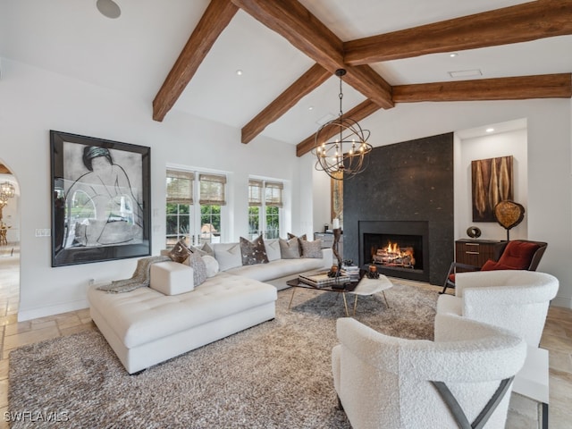 living room featuring a fireplace, lofted ceiling with beams, and a notable chandelier