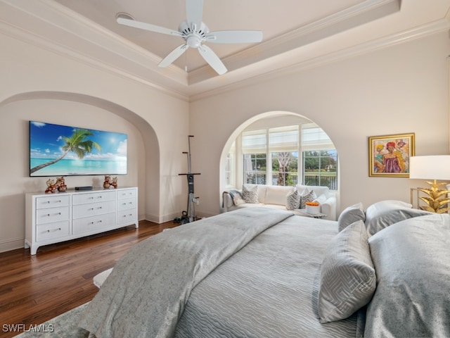 bedroom featuring ceiling fan, dark hardwood / wood-style floors, a raised ceiling, and ornamental molding