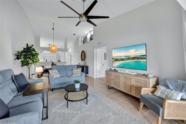 tiled living room featuring ceiling fan and high vaulted ceiling