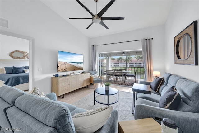 tiled living room featuring ceiling fan and high vaulted ceiling