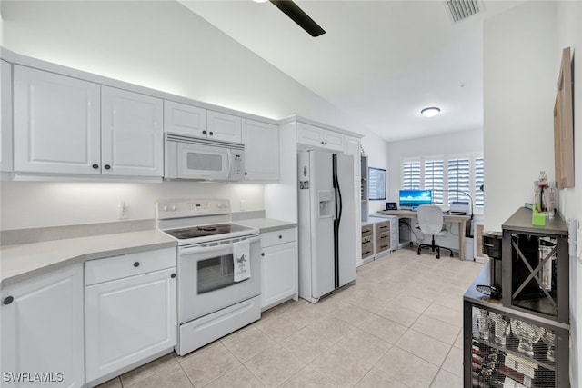 kitchen featuring white cabinets, lofted ceiling, light tile patterned flooring, and white appliances