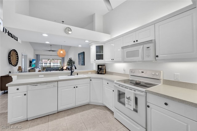 kitchen with ceiling fan, sink, kitchen peninsula, white appliances, and white cabinets