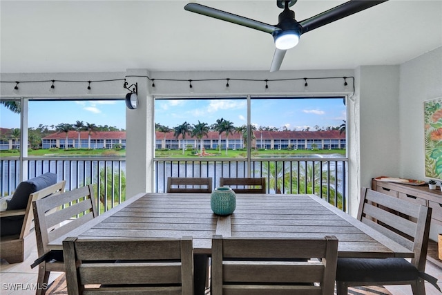 sunroom with a water view, a wealth of natural light, and ceiling fan