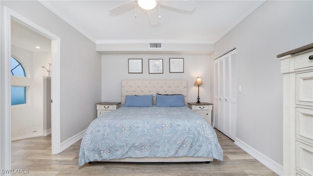 bedroom featuring ornamental molding, light hardwood / wood-style floors, ceiling fan, and a closet