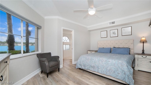 bedroom with crown molding, a water view, light wood-type flooring, and ceiling fan