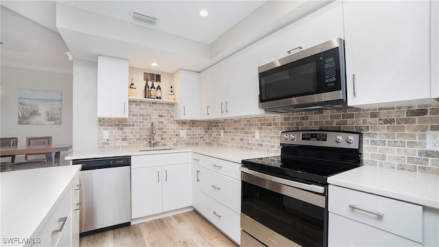 kitchen featuring white cabinetry, sink, tasteful backsplash, and stainless steel appliances