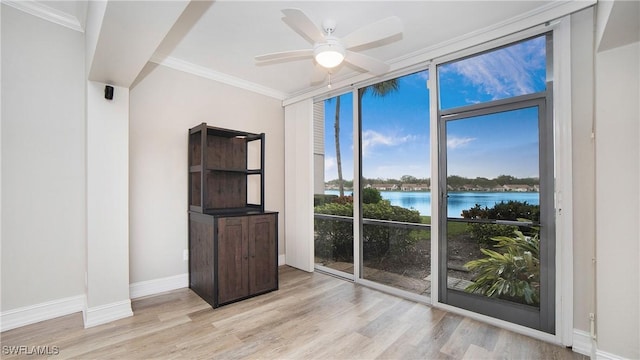 unfurnished room with a water view, ceiling fan, crown molding, and light wood-type flooring