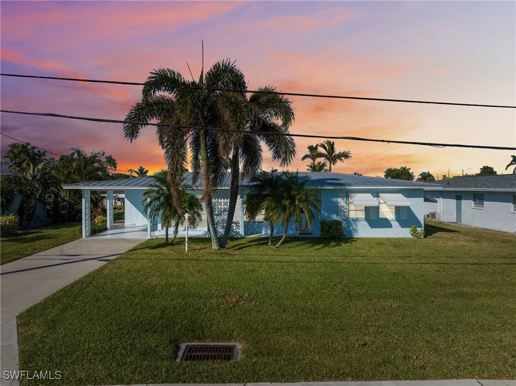 view of front facade with a lawn and a carport