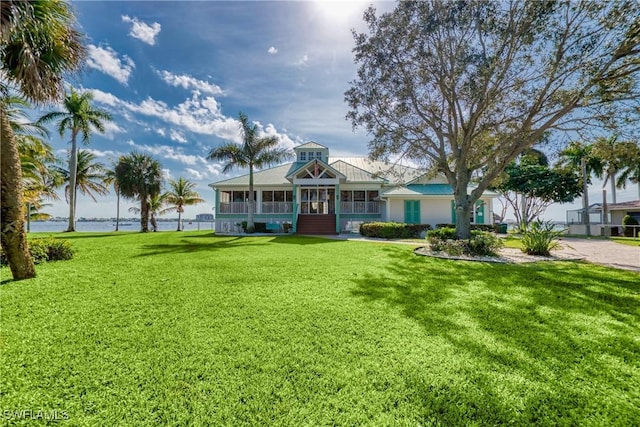 view of front facade with a front yard and a sunroom