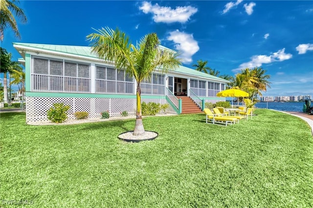 view of front facade featuring a sunroom and a front yard