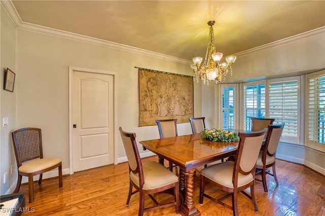 dining space featuring a chandelier, wood-type flooring, and crown molding