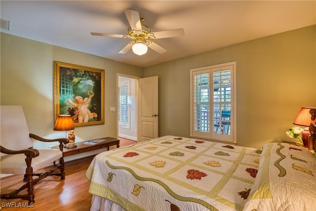 bedroom featuring multiple windows, ceiling fan, and wood-type flooring