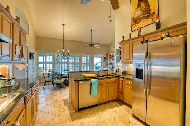 kitchen with kitchen peninsula, light tile patterned floors, stainless steel appliances, and ceiling fan with notable chandelier