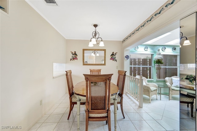 tiled dining space with a skylight and a chandelier