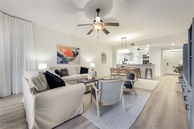 living room with a ceiling fan, light wood-type flooring, and recessed lighting