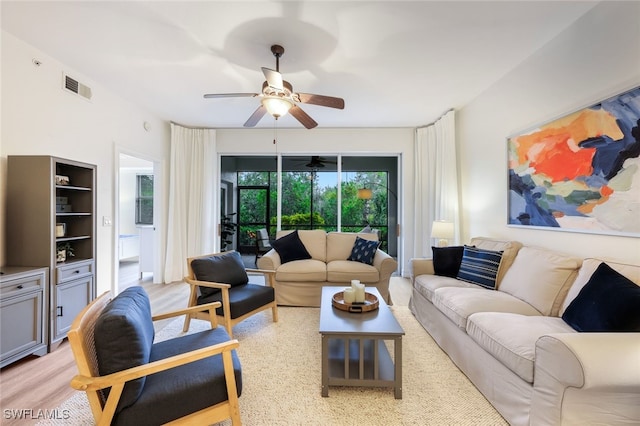 living room with light wood-style floors, visible vents, and ceiling fan