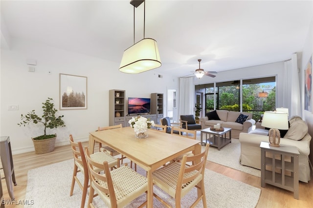 dining space with a ceiling fan, baseboards, and light wood finished floors