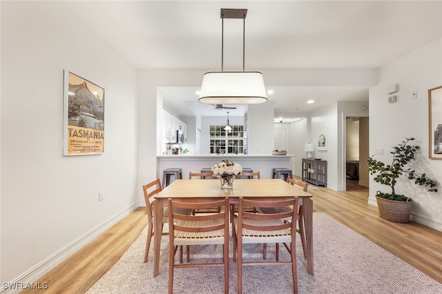 dining area with light wood finished floors, baseboards, and recessed lighting