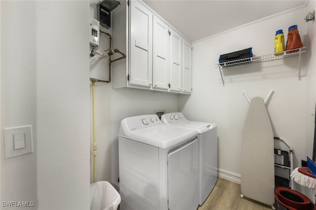 laundry area with cabinet space, washing machine and dryer, baseboards, and light wood finished floors