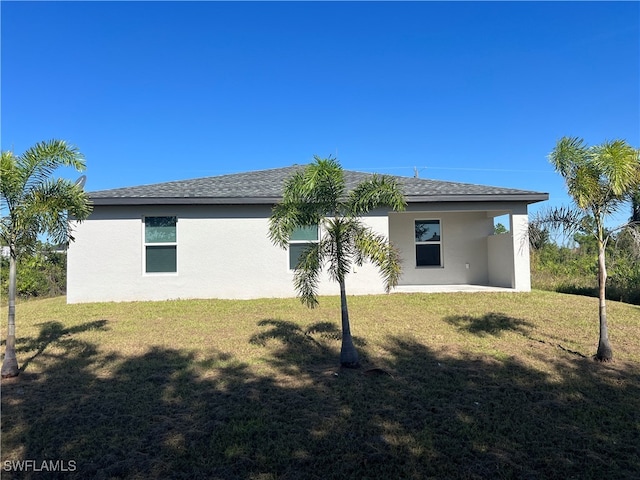 rear view of property featuring a yard and a patio