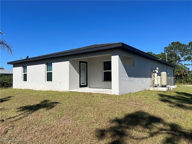 back of property with a yard and a patio