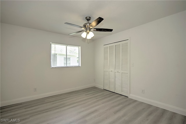 unfurnished bedroom with ceiling fan, light hardwood / wood-style floors, and a closet