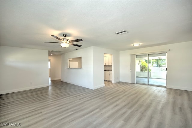 unfurnished living room featuring a textured ceiling, light hardwood / wood-style flooring, and ceiling fan