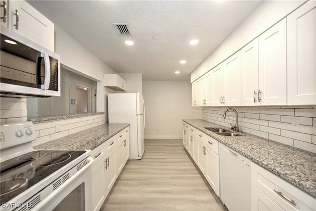 kitchen featuring white cabinets, white appliances, and sink