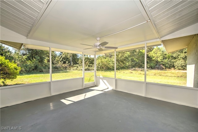 unfurnished sunroom featuring ceiling fan, a healthy amount of sunlight, and vaulted ceiling