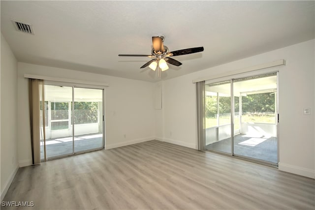 empty room with a textured ceiling, light hardwood / wood-style floors, and ceiling fan