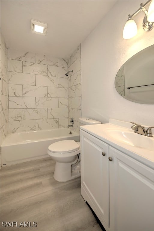 full bathroom with toilet, hardwood / wood-style floors, vanity, and tiled shower / bath