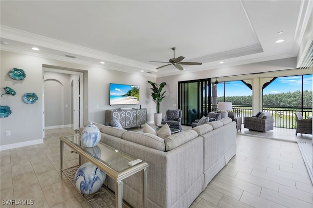 living room featuring a tray ceiling, ceiling fan, and crown molding