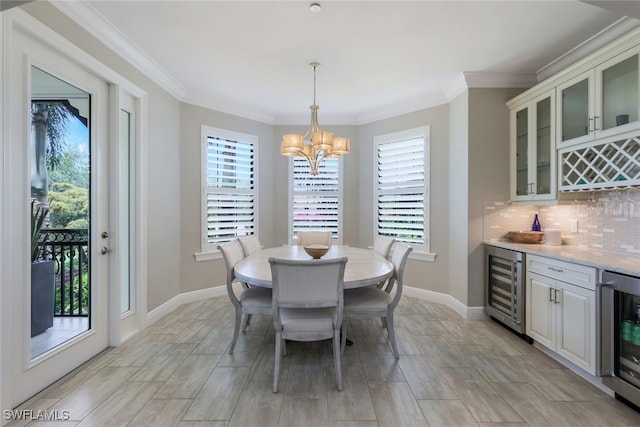 dining space featuring an inviting chandelier, wine cooler, and a healthy amount of sunlight