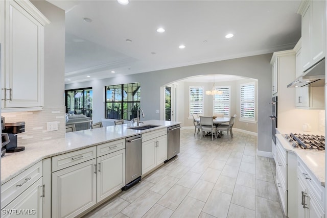 kitchen with tasteful backsplash, white cabinetry, sink, and stainless steel appliances