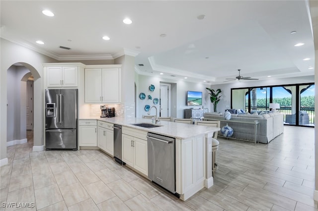 kitchen with white cabinetry, sink, ceiling fan, and stainless steel appliances