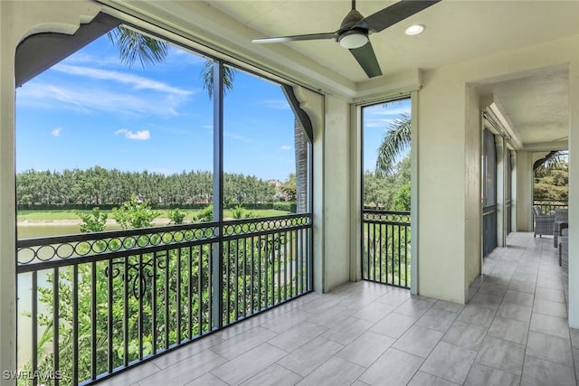 unfurnished sunroom featuring ceiling fan