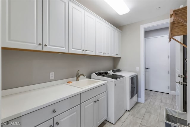 washroom featuring sink, cabinets, and independent washer and dryer