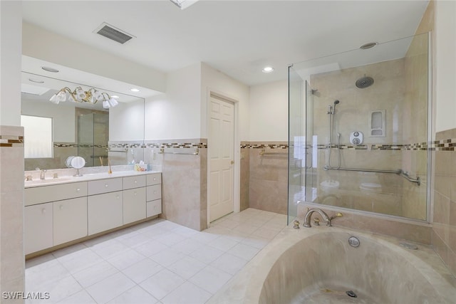 bathroom featuring tile patterned floors, vanity, plus walk in shower, and tile walls