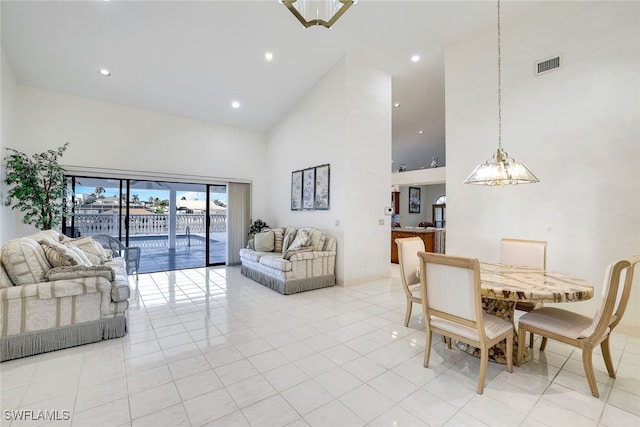 tiled dining area featuring high vaulted ceiling