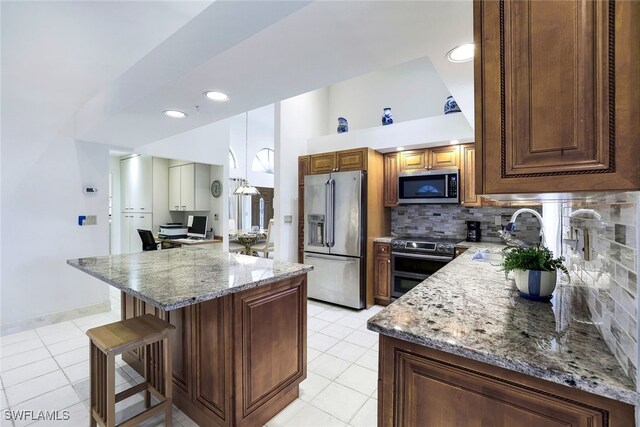 kitchen featuring light stone countertops, decorative backsplash, stainless steel appliances, and sink