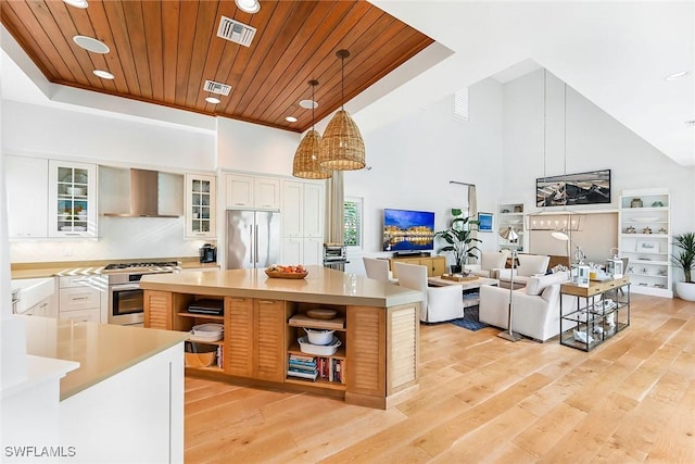 kitchen with white cabinets, wall chimney exhaust hood, wood ceiling, and appliances with stainless steel finishes