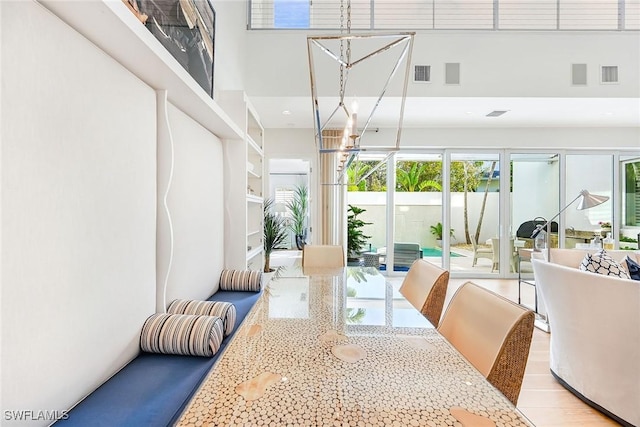 dining space featuring a high ceiling and light wood-type flooring