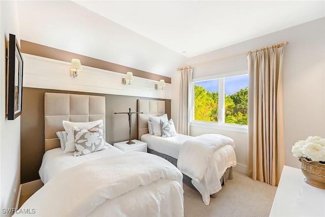 bedroom with light carpet and lofted ceiling