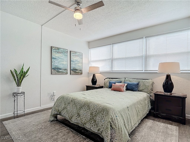 bedroom featuring ceiling fan, hardwood / wood-style floors, and a textured ceiling