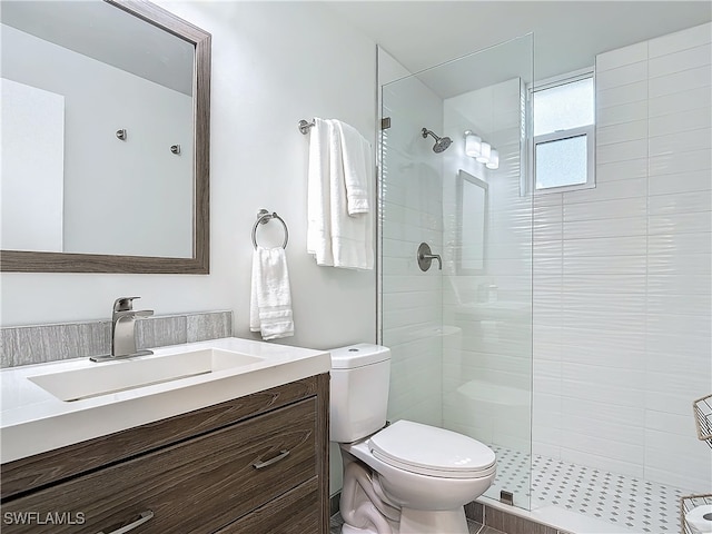 bathroom featuring tile patterned floors, vanity, a shower with shower door, and toilet