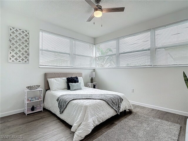 bedroom with hardwood / wood-style floors, ceiling fan, and a textured ceiling