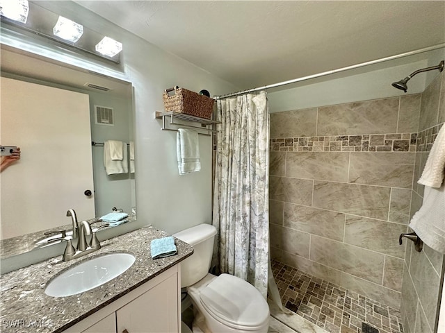 bathroom featuring a shower with shower curtain, vanity, and toilet