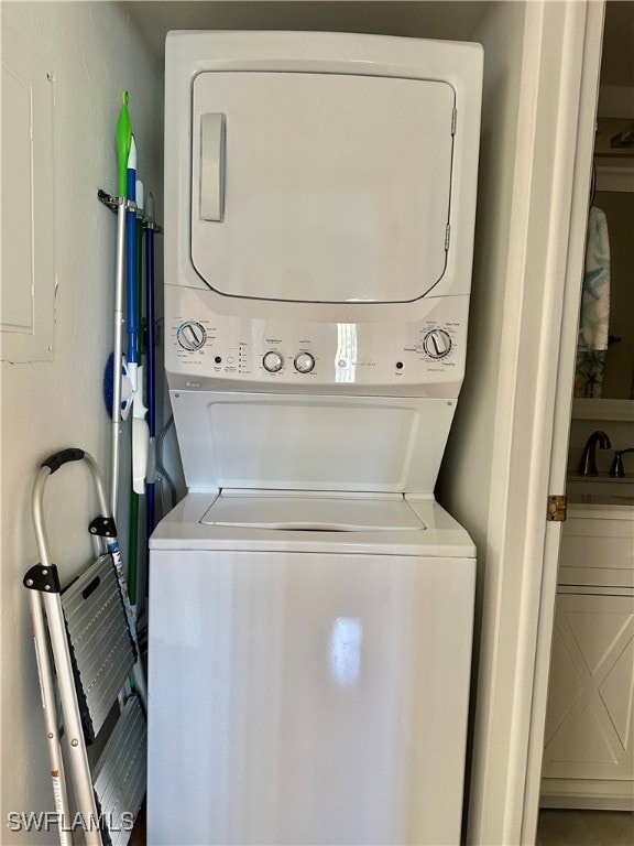 laundry room featuring stacked washer / drying machine