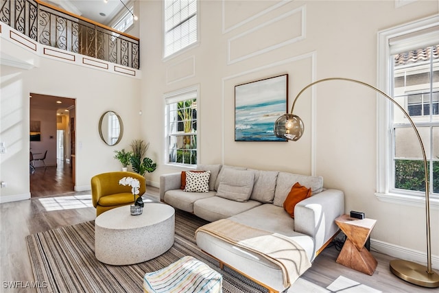 living room with a wealth of natural light, hardwood / wood-style floors, and a high ceiling