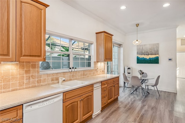 kitchen featuring crown molding, sink, pendant lighting, light hardwood / wood-style flooring, and dishwasher